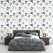 Une chambre moderne avec un papier peint floral aux motifs délicats de fleurs roses et bleues sur fond blanc, créant une ambiance douce et apaisante.
