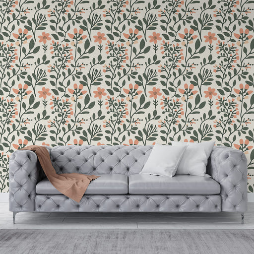 Un salon élégant avec un papier peint floral aux motifs de feuilles vertes et fleurs corail sur fond crème, créant une atmosphère chaleureuse et accueillante.