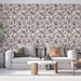 Un salon élégant avec un papier peint floral beige orné de motifs violets délicats, créant une atmosphère douce et accueillante.