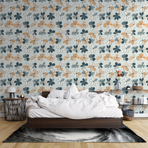 Une chambre accueillante avec un papier peint floral aux motifs colorés de fleurs et feuilles dans des teintes douces de bleu, orange et beige, créant une atmosphère joyeuse et apaisante.