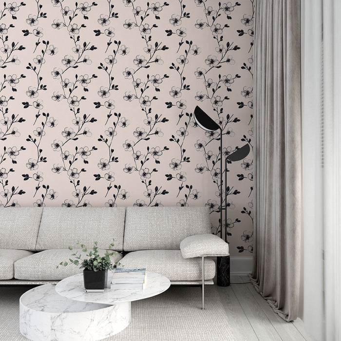Un salon moderne avec un papier peint floral sur fond rose pâle, orné de motifs noirs délicats qui créent une atmosphère élégante et apaisante.
