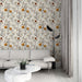 Un salon moderne avec un papier peint floral aux motifs délicats de fleurs orange et blanches sur fond crème, créant une ambiance chaleureuse et accueillante.