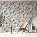Une pièce lumineuse avec un papier peint floral aux motifs de fleurs orange et bleues sur fond clair, créant une ambiance douce et chaleureuse.