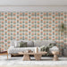 Un salon lumineux avec un papier peint floral aux motifs de fleurs orange et vertes sur fond clair, créant une ambiance chaleureuse et accueillante.