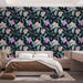Une chambre moderne avec un papier peint floral aux motifs de fleurs violettes et feuilles vertes sur fond noir, créant une atmosphère élégante et apaisante.