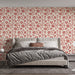 Une chambre élégante avec un papier peint floral rouge sur fond crème, créant une atmosphère chaleureuse et accueillante.