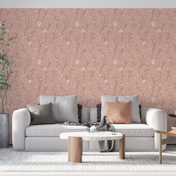Un salon lumineux avec un papier peint floral rose aux motifs délicats de branches et de fleurs blanches, créant une ambiance douce et accueillante.
