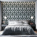 Une chambre élégante avec un papier peint floral vert foncé sur fond clair, créant une atmosphère apaisante et raffinée.