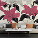 Un salon élégant avec un papier peint floral aux grandes fleurs roses et blanches sur fond clair, créant une ambiance à la fois chaleureuse et artistique.