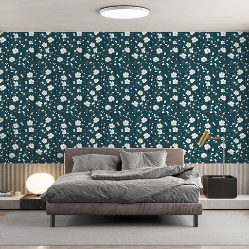 Une chambre moderne avec un papier peint floral bleu canard orné de délicates fleurs blanches, créant une atmosphère apaisante et élégante.