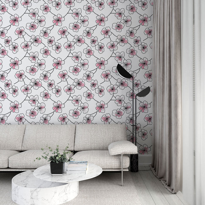 Un salon moderne avec un papier peint floral aux motifs de fleurs roses et noires sur fond blanc, créant une ambiance douce et accueillante.