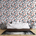 Une chambre moderne avec un papier peint floral aux motifs de fleurs orange et noires sur fond blanc, créant une ambiance joyeuse et accueillante.