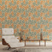 Une pièce moderne avec un papier peint floral aux motifs de feuilles orange et turquoise sur fond beige, créant une atmosphère chaleureuse et accueillante.