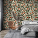 Une chambre moderne avec un papier peint floral aux motifs de coquelicots rouges et noirs sur fond crème, créant une atmosphère chaleureuse et accueillante.