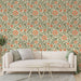 Un salon lumineux avec un papier peint floral aux motifs de grandes fleurs orange sur fond crème, créant une ambiance chaleureuse et accueillante.