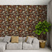 Un salon moderne avec un papier peint floral aux teintes chaudes de brun, beige et rouge, créant une atmosphère accueillante et naturelle.