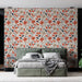 Une chambre moderne avec un papier peint floral aux motifs colorés d'orange et de beige, créant une atmosphère chaleureuse et accueillante.