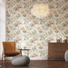 Une pièce de vie élégante avec un papier peint floral aux motifs de roses pastel et feuillages sur fond clair, créant une ambiance douce et accueillante.