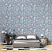 Une chambre moderne avec un papier peint floral bleu clair orné de motifs de fleurs roses et de feuillages, créant une ambiance douce et accueillante.
