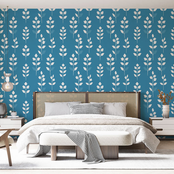 Une chambre moderne avec un papier peint bleu vif orné de motifs floraux blancs, créant une ambiance fraîche et apaisante.