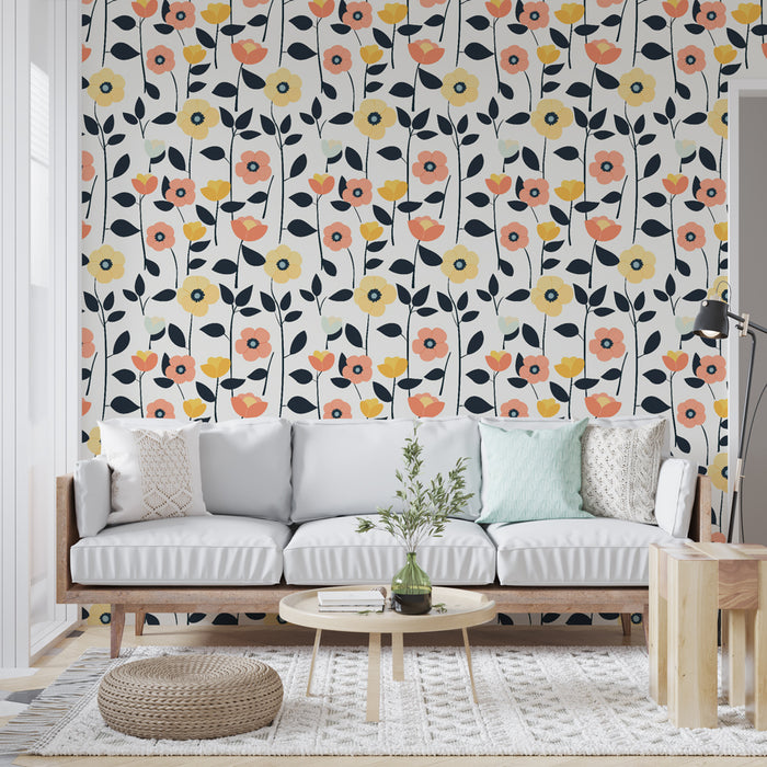 Un salon lumineux avec un papier peint floral aux motifs colorés de fleurs roses, jaunes et blanches sur fond clair, créant une ambiance joyeuse et accueillante.