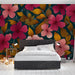 Une chambre contemporaine avec un papier peint floral aux grandes fleurs roses et jaunes sur fond bleu foncé, créant une ambiance chaleureuse et dynamique.