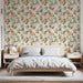 Une chambre lumineuse avec un papier peint floral aux motifs de fleurs roses et vertes sur fond clair, créant une atmosphère douce et apaisante.