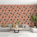Un salon moderne avec un papier peint floral aux grandes fleurs noires sur fond corail, créant une atmosphère chaleureuse et accueillante.