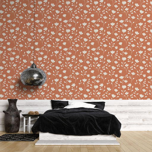 Une chambre moderne avec un papier peint terracotta orné de motifs floraux blancs, créant une atmosphère chaleureuse et accueillante.