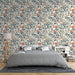 Une chambre moderne avec un papier peint floral aux motifs colorés, mêlant des fleurs orange et bleues sur un fond clair, créant une ambiance chaleureuse et accueillante.