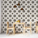 Une salle à manger lumineuse avec un papier peint floral noir et beige, aux motifs étoilés, créant une ambiance à la fois élégante et chaleureuse.