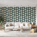 Une pièce de salon avec un papier peint floral aux motifs de fleurs stylisées beige sur fond vert, créant une ambiance joyeuse et accueillante.