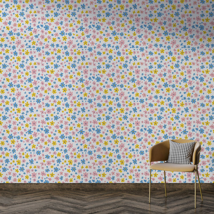 Une pièce lumineuse avec un papier peint floral aux motifs colorés de fleurs bleues, roses et jaunes sur fond blanc, créant une ambiance joyeuse et fraîche.