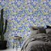 Une chambre moderne avec un papier peint floral coloré aux motifs de fleurs roses, jaunes et bleues sur fond blanc, créant une atmosphère joyeuse et dynamique.