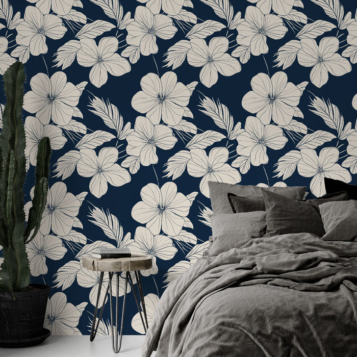 Une chambre moderne avec un papier peint floral bleu marine et crème, aux motifs de grandes fleurs et feuillages, créant une atmosphère apaisante et élégante.