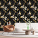 Un salon moderne avec un papier peint floral noir, orné de fleurs blanches et de feuillages dorés, créant une ambiance élégante et sophistiquée.