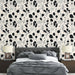 Une chambre moderne avec un papier peint floral en noir et blanc, agrémenté de touches pastel, créant une ambiance élégante et apaisante.