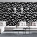 Un salon moderne avec un papier peint floral noir et blanc présentant des branches délicates, créant une ambiance élégante et contemporaine.