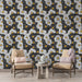 Un salon accueillant avec un papier peint floral noir et blanc orné de grandes fleurs blanches et de touches jaunes, créant une ambiance dynamique et chaleureuse.