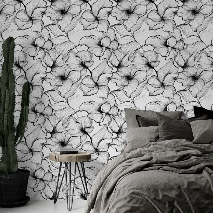 Une chambre élégante avec un papier peint floral noir et blanc aux motifs délicats, créant une atmosphère artistique et apaisante.