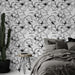 Une chambre élégante avec un papier peint floral noir et blanc aux motifs délicats, créant une atmosphère artistique et apaisante.