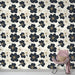 Une chambre élégante avec un papier peint floral noir et blanc, orné de fleurs stylisées et de touches dorées, créant une atmosphère sophistiquée et apaisante.
