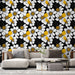 Un salon moderne avec un papier peint floral noir, blanc et jaune, créant une ambiance dynamique et joyeuse grâce à ses motifs éclatants.