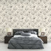 Une chambre élégante avec un papier peint floral beige et noir, présentant des motifs délicats de fleurs sur fond clair, créant une atmosphère apaisante et raffinée.