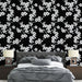 Une chambre moderne avec un papier peint floral noir et blanc, présentant des motifs de fleurs délicates sur fond sombre, créant une ambiance élégante et apaisante.
