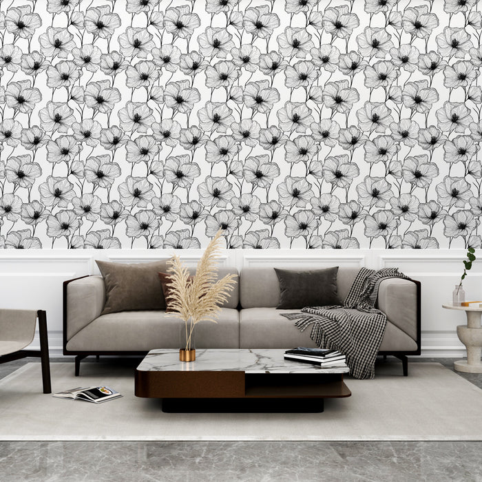 Un salon élégant avec un papier peint floral noir et blanc aux motifs délicats, créant une atmosphère artistique et contemporaine.