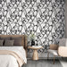 Une chambre élégante avec un papier peint floral noir et blanc, aux motifs délicats de branches et de fleurs, créant une ambiance moderne et apaisante.
