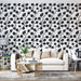 Un salon contemporain avec un papier peint floral noir sur fond blanc, créant une atmosphère élégante et dynamique.