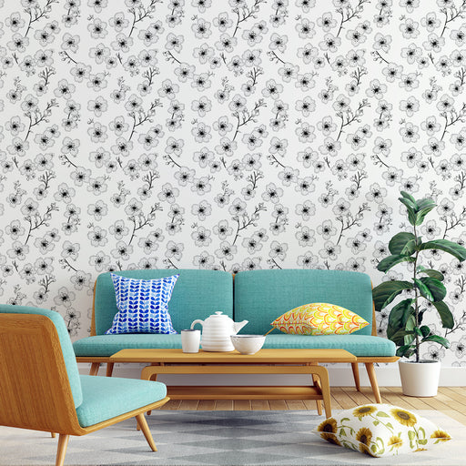 Un salon moderne avec un papier peint floral noir et blanc représentant des fleurs délicates sur fond clair, créant une atmosphère élégante et apaisante.