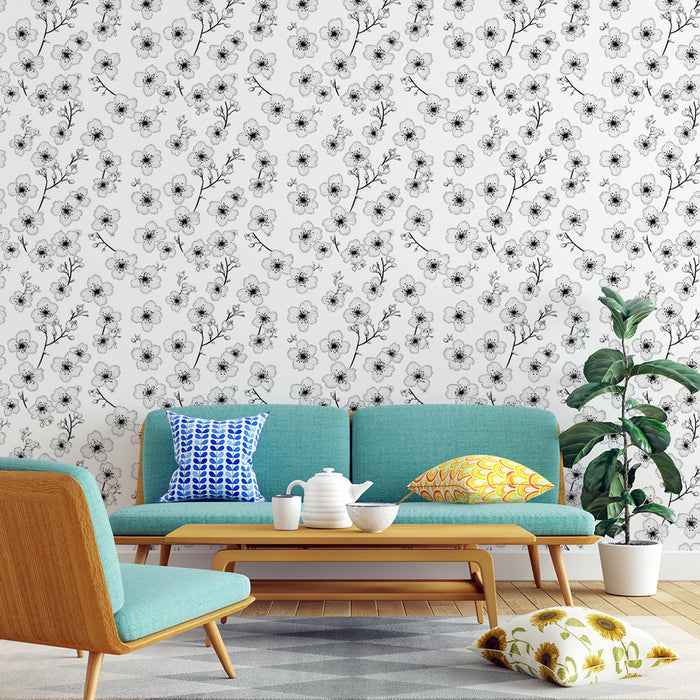 Un salon moderne avec un papier peint floral noir et blanc représentant des fleurs délicates sur fond clair, créant une atmosphère élégante et apaisante.